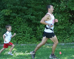 Photo of son chasing Dad finishing the 30 mile Psummer Psycho Trail Race.