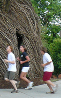 Photo of Dog Days group running passed bird's nest sculpture by Spooner Hall.