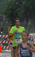 Andrea Stewart and Hunter Turley running in the rain at the Mass Street Mile.