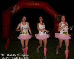 Photo of 3 finishers in tutus.