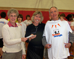 Photo of Janet and John Huchingson presented the runLawrence donation check to Michel Loomis for the Central Liberty Memorial Middle School Smart Strength program.